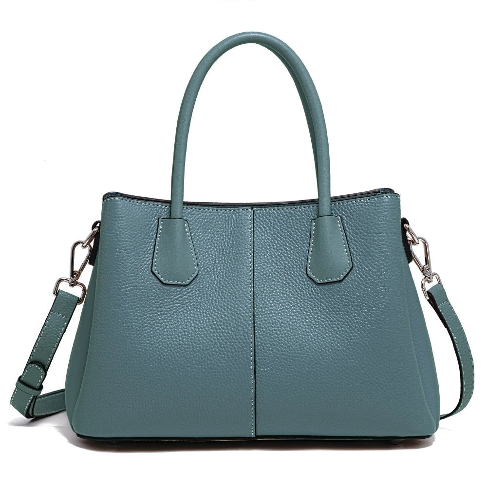 Teal handbag with a shoulder strap on a white background