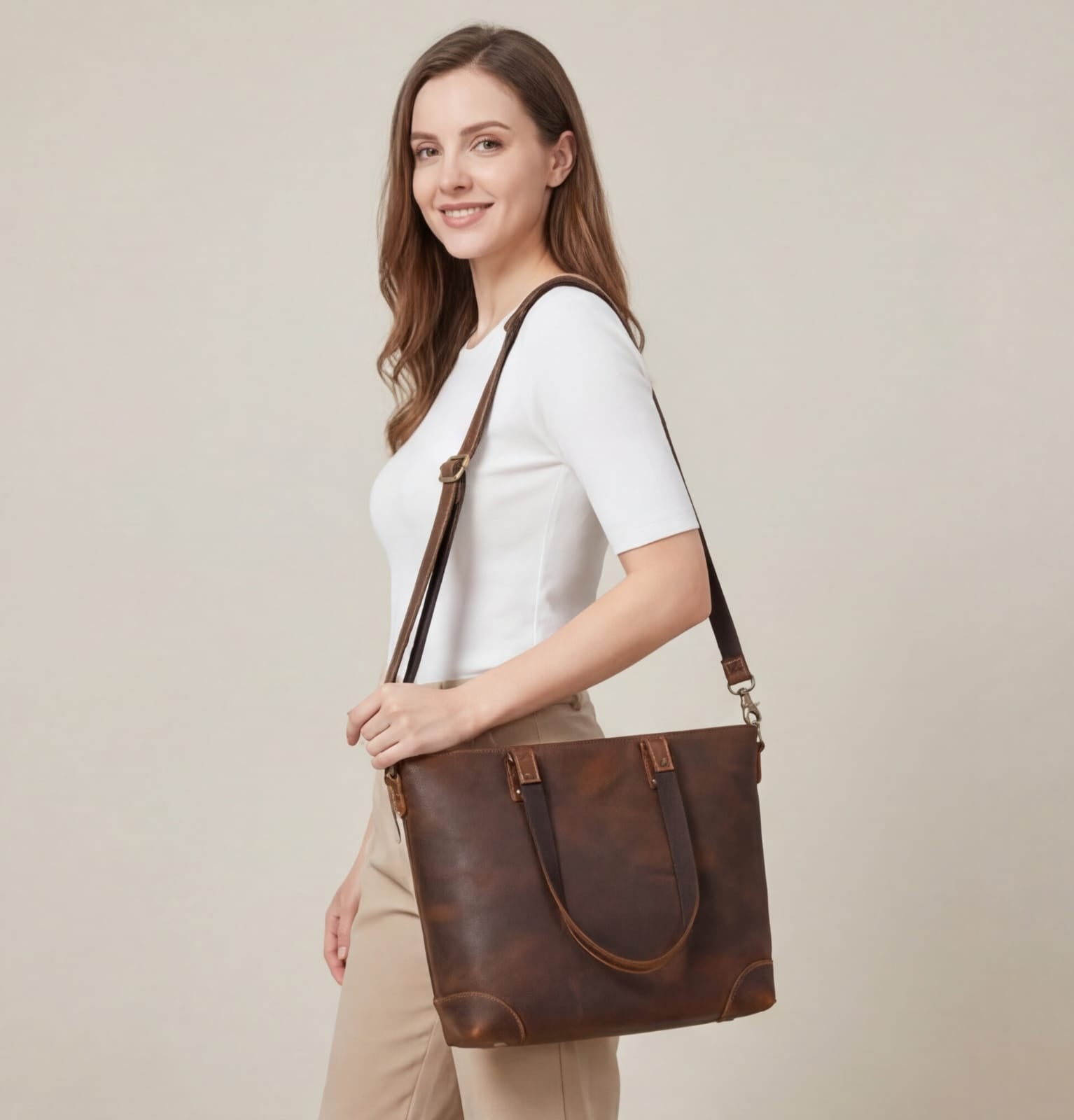 Woman holding a brown leather bag against a beige background