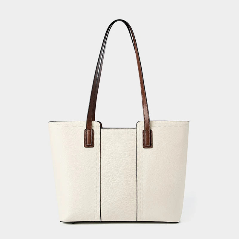 White tote bag with brown handles on a light gray background
