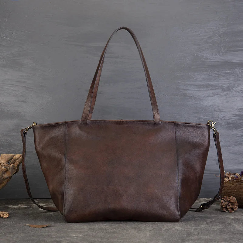 Brown leather tote bag on a gray background