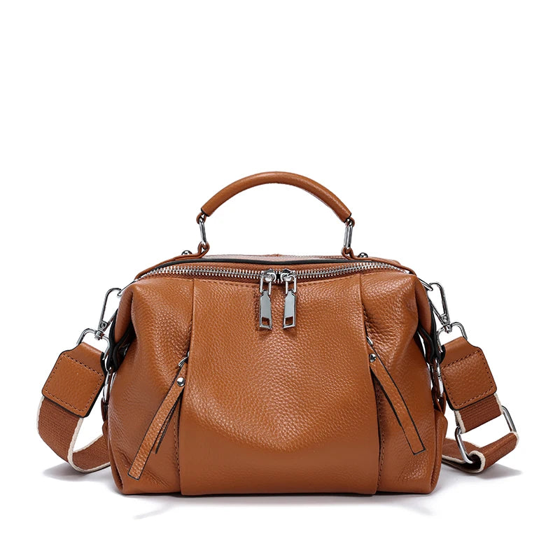 Brown leather handbag with multiple zippers on a white background