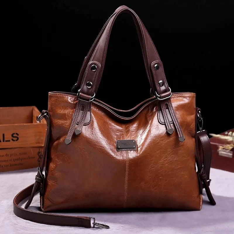 Vintage brown leather tote bag with dark brown handles and a detachable shoulder strap, displayed against a black background.