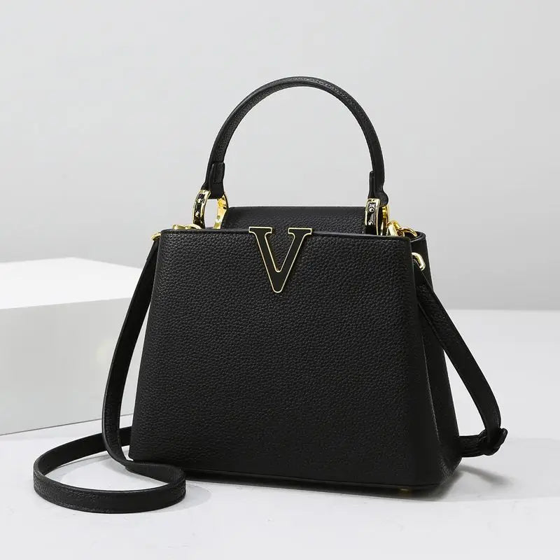 Black handbag with gold accents on a white background