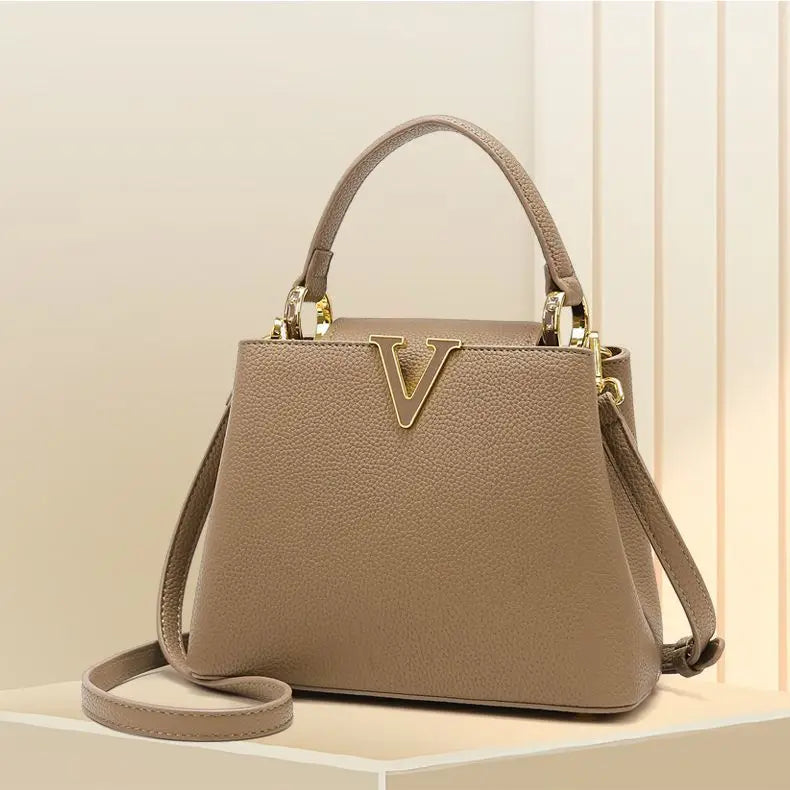 Beige handbag with gold accents on a light background