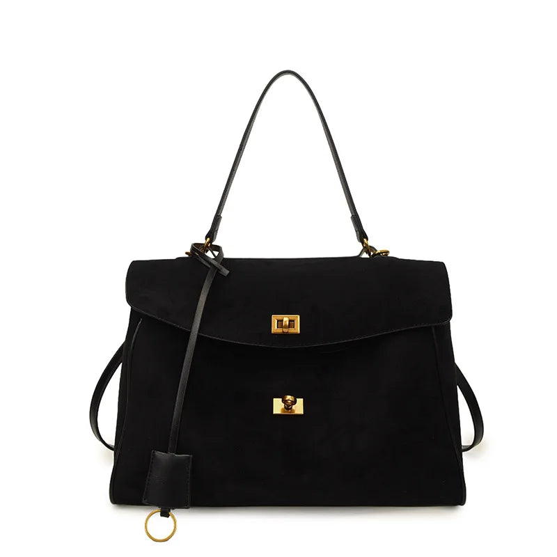 Black handbag with gold accents on a white background