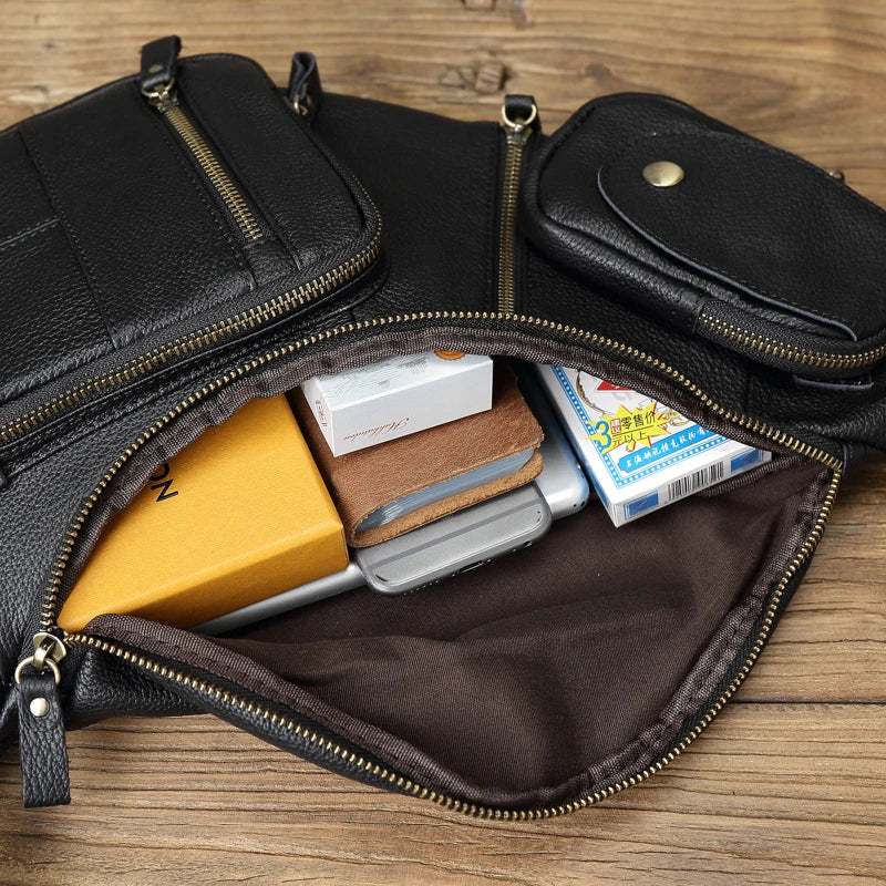 Black leather pouch with gold zipper containing various items on a wooden surface
