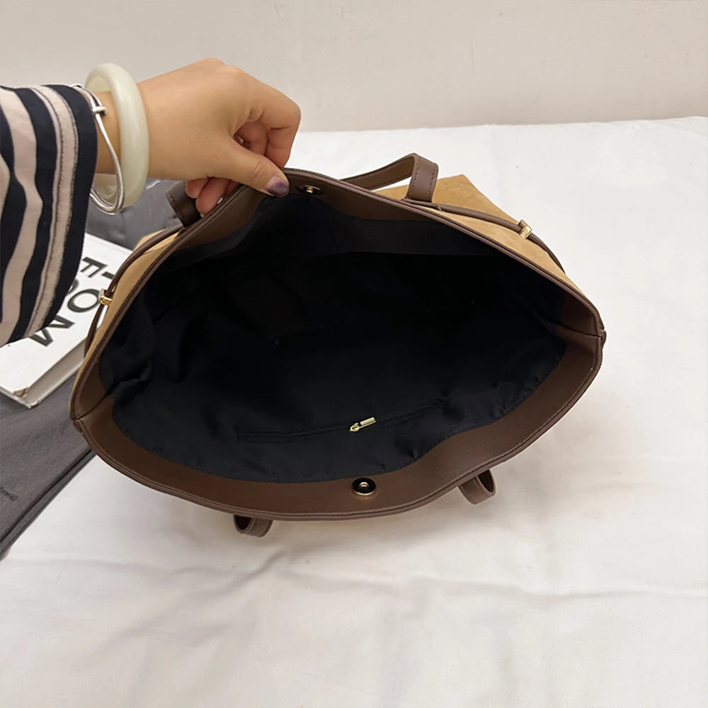 Brown backpack being held open on a white surface