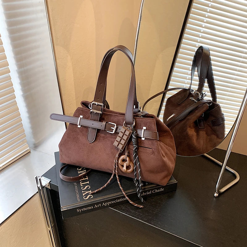 Brown handbag on a stack of books with a mirror reflection.