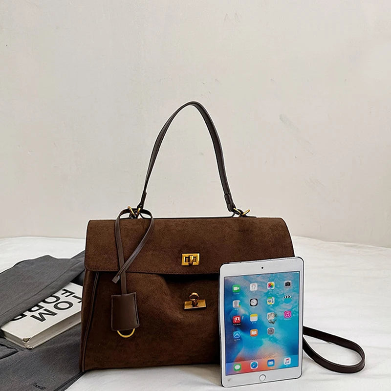 Brown handbag with a phone on a white surface