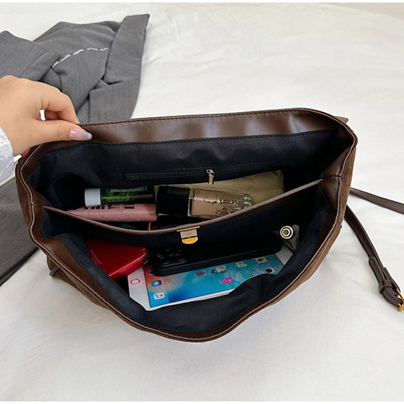 Brown handbag with items inside on a white surface