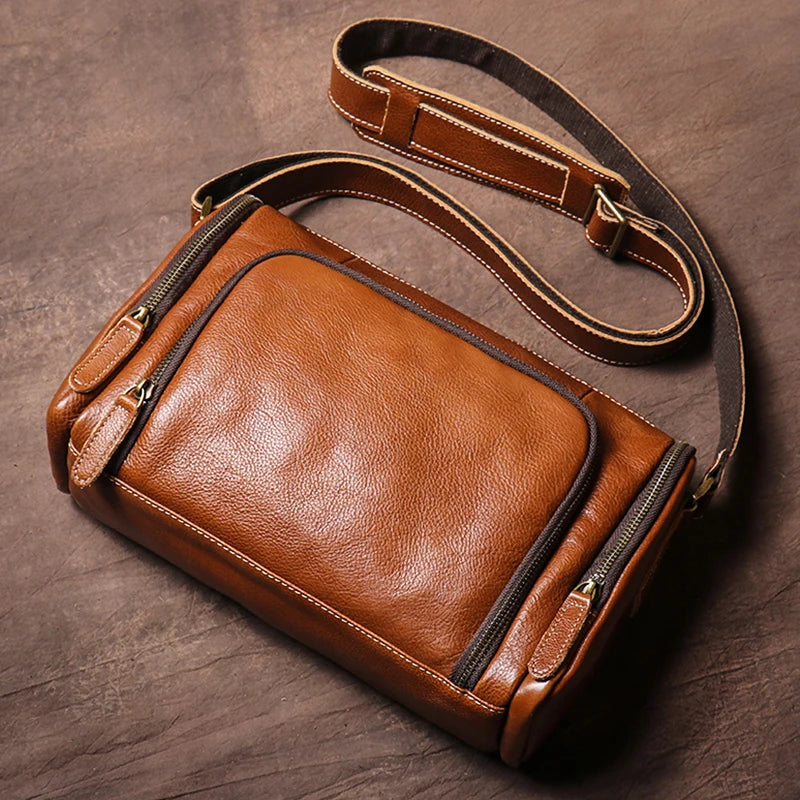 Brown leather crossbody bag on a wooden surface