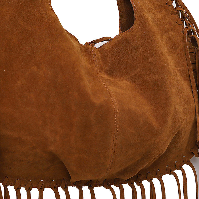 Brown leather handbag with fringe details on a white background