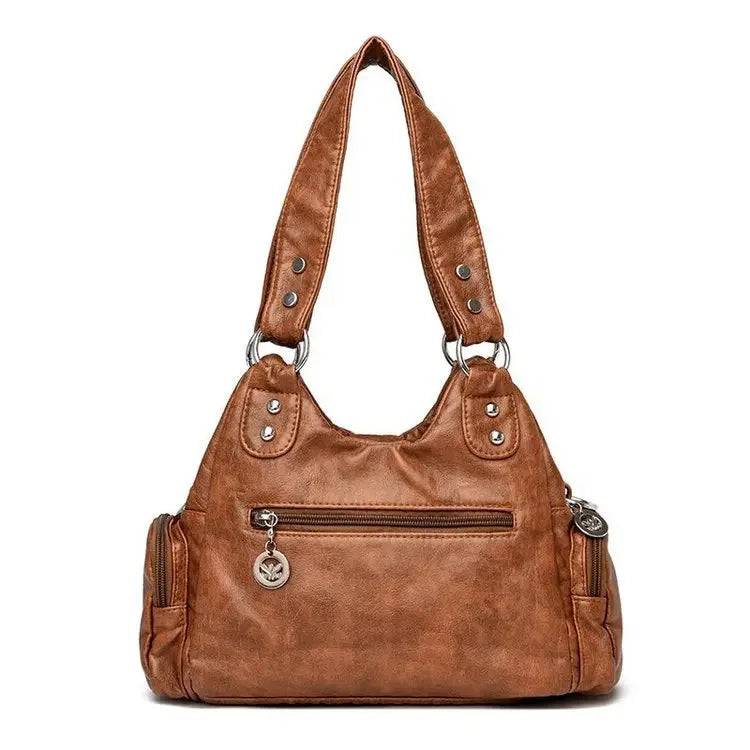 Brown leather handbag with silver hardware on a white background