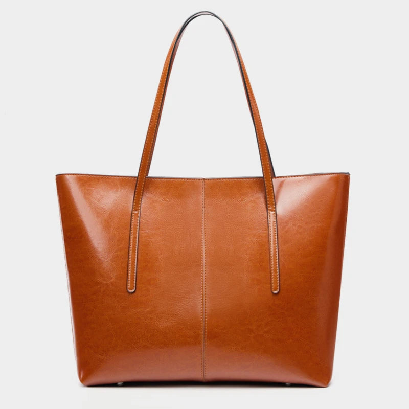 Brown leather tote bag on a light gray background