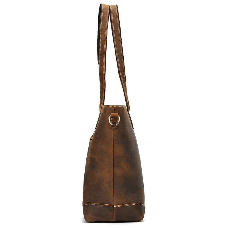 Brown leather tote bag with a strap on a white background