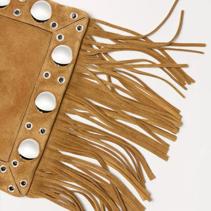 Brown suede clutch with white circular embellishments and fringes on a light gray background