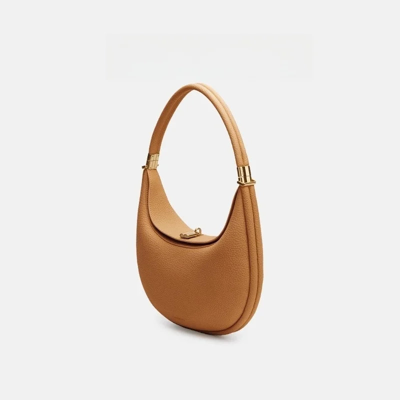 Caramel handbag with gold accents on a light gray background