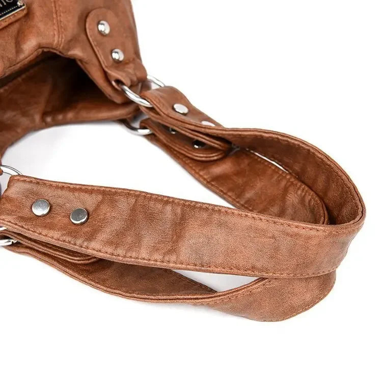 Close-up of a brown leather handbag with a strap on a white background