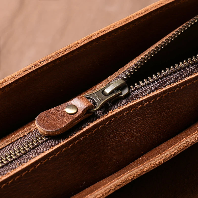 Close-up of a brown leather briefcase with a zipper
