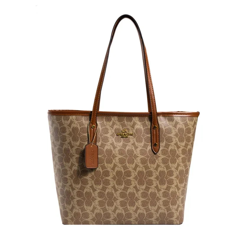 Coach tote bag with brown handle and tag on a white background