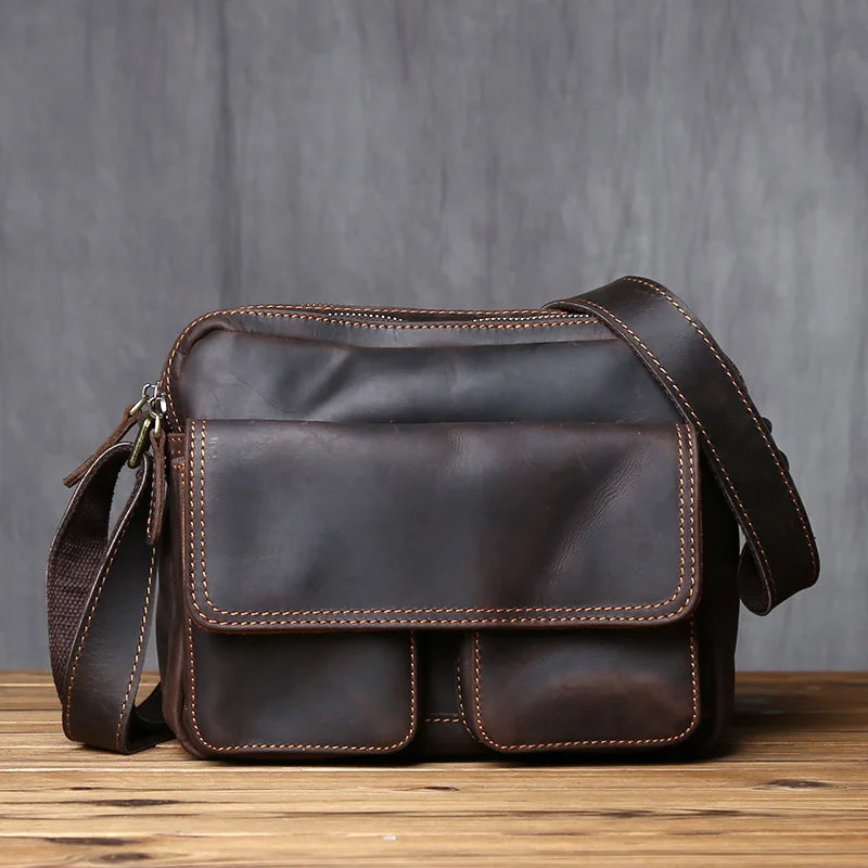 Dark Brown leather shoulder bag on a wooden surface with a gray background