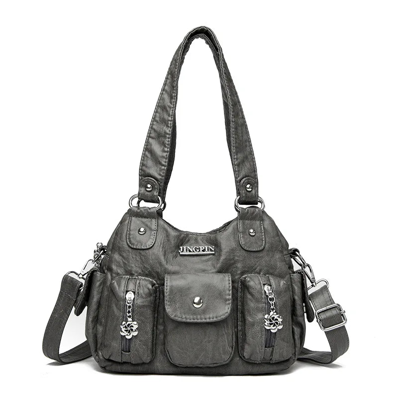 Gray handbag with multiple pockets and straps on a white background