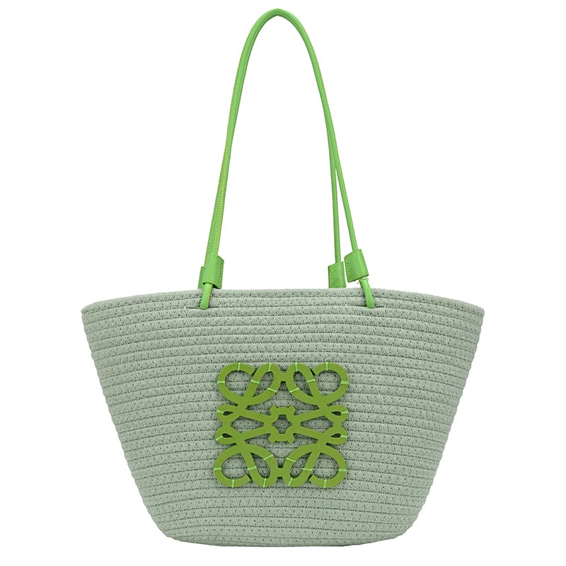 Green woven bag with decorative cutout design on a white background
