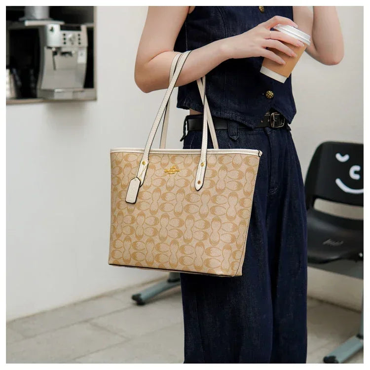 Person holding a beige handbag with a coffee cup in an indoor setting
