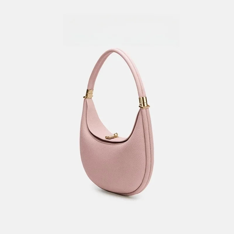 Pink handbag with gold accents on a light gray background
