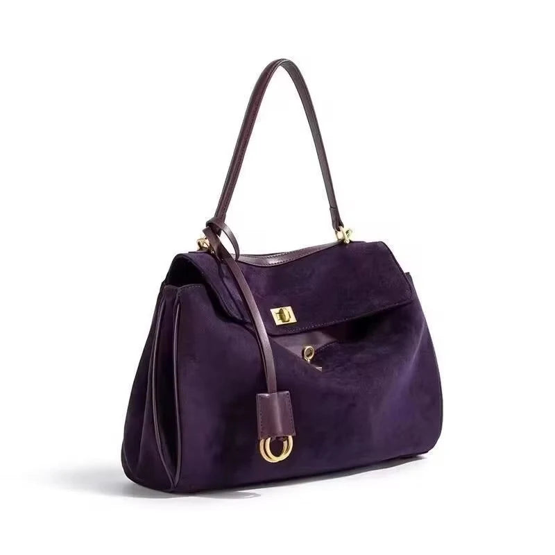 Purple handbag with gold accents on a white background