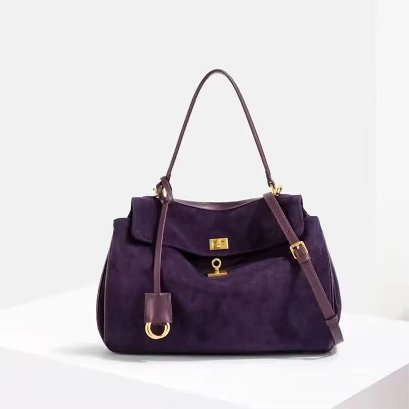 Purple handbag with gold accents on a white background