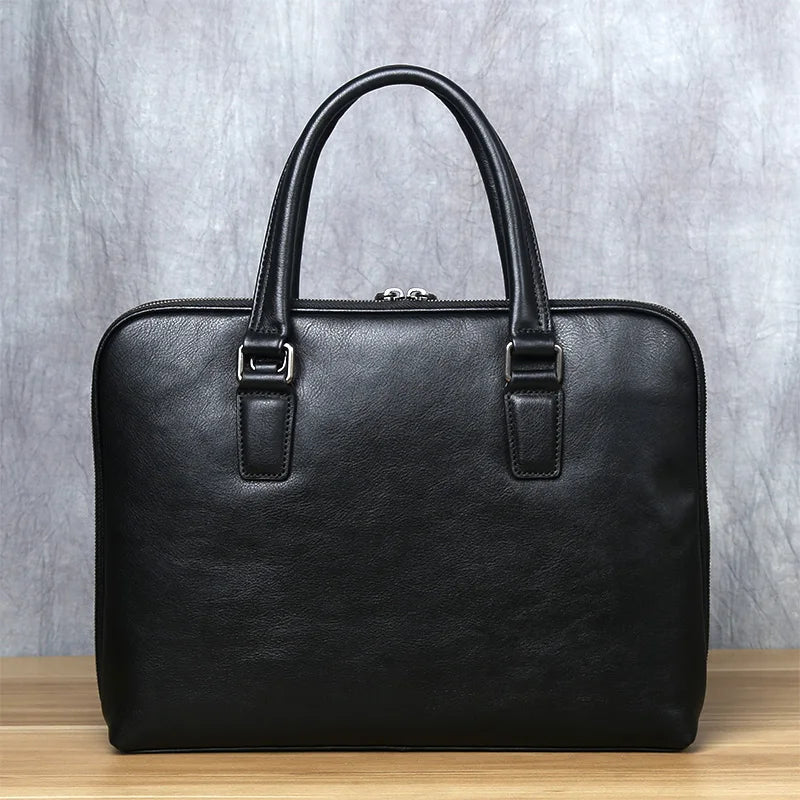 Black leather briefcase on a wooden surface with a gray textured background