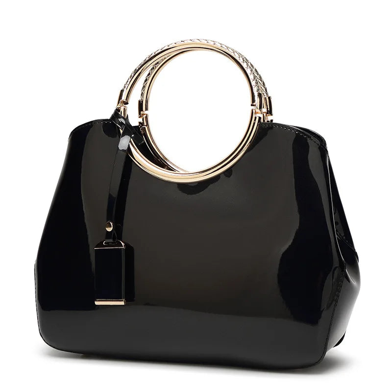 Black handbag with gold ring handle on a white background