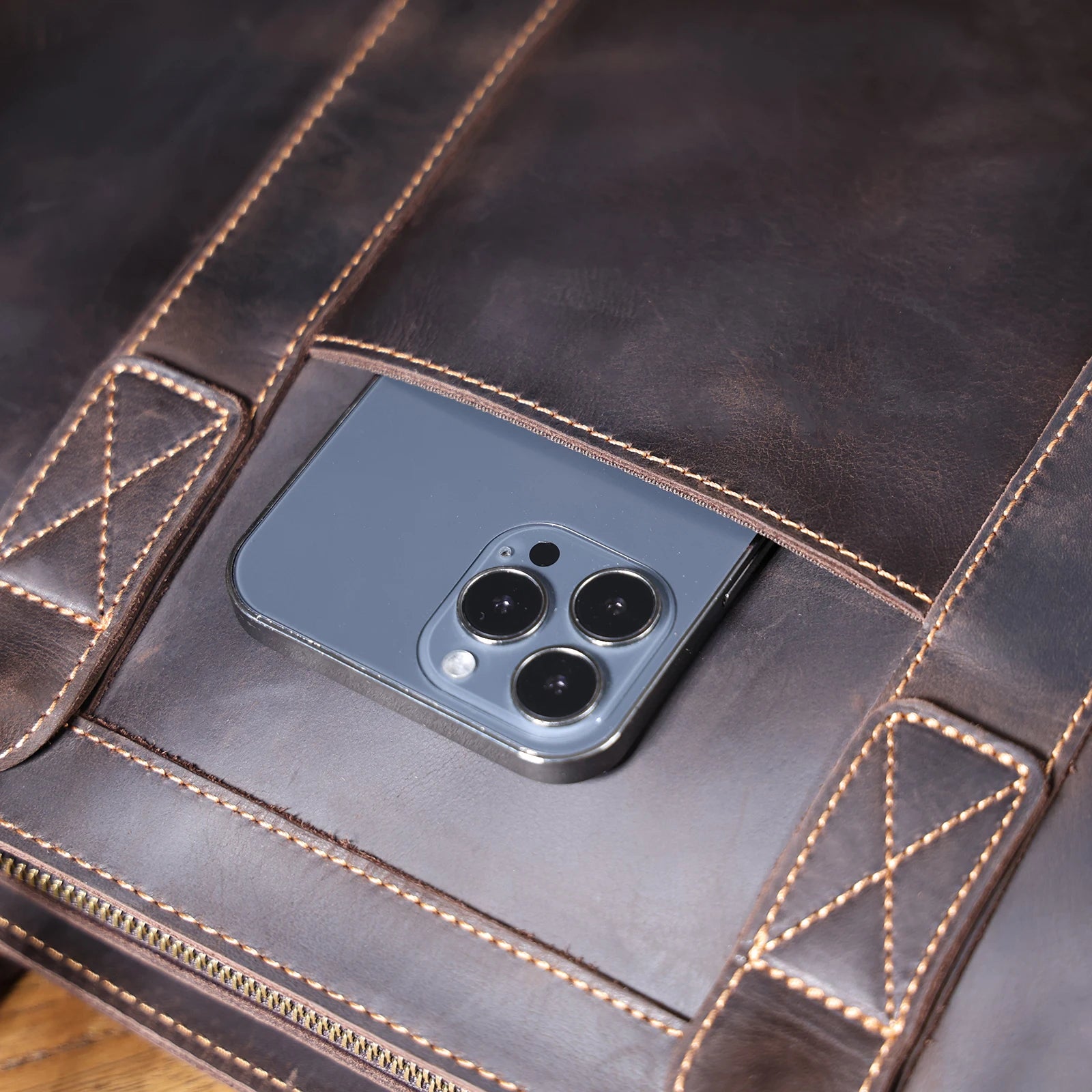 Smartphone with a dark blue case on a brown leather surface