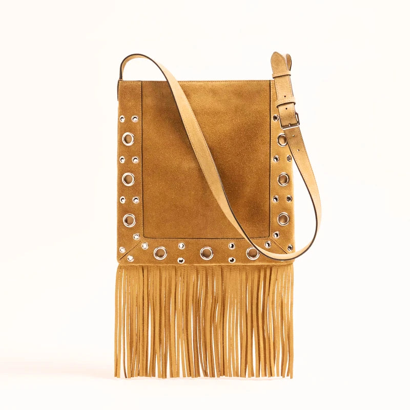 Tan suede handbag with fringe and grommet details on a white background