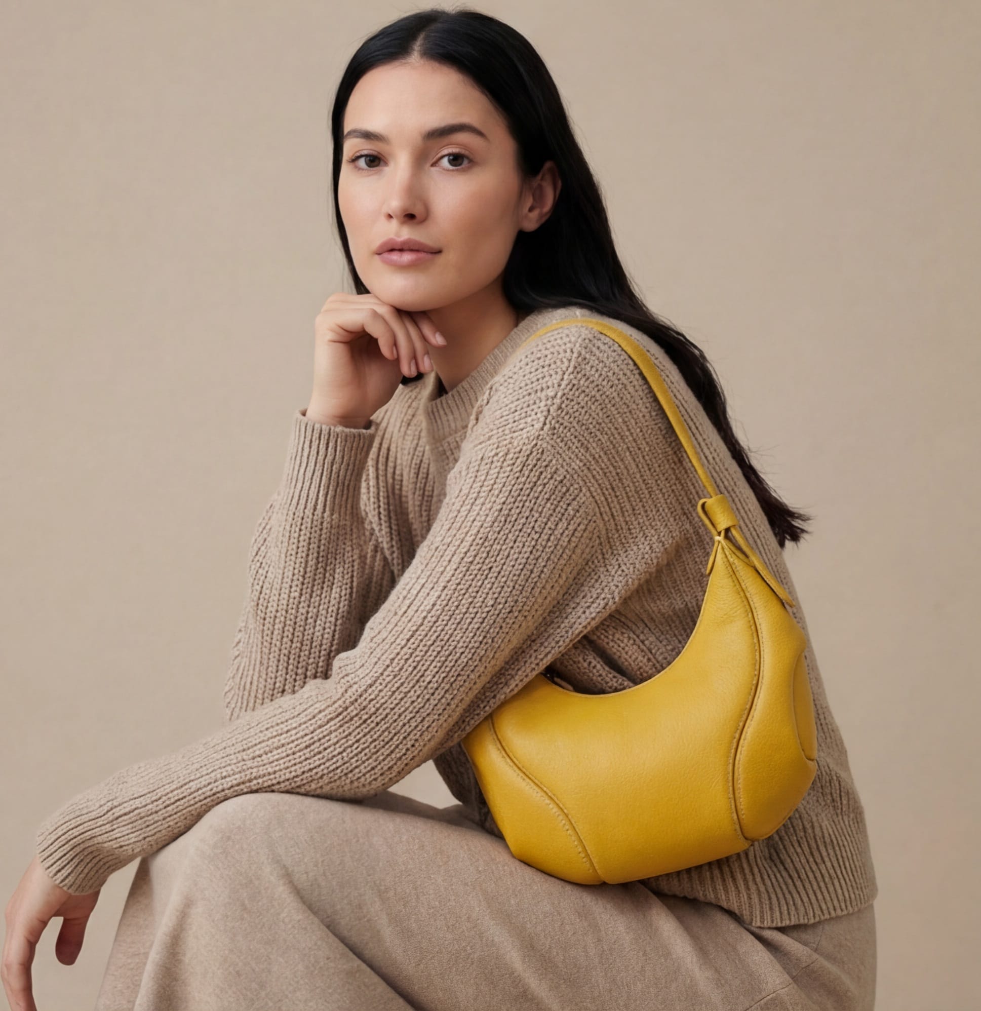 Woman holding a yellow handbag against a beige background