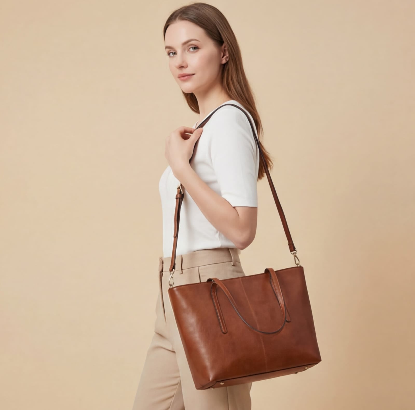 Woman holding a brown leather handbag against a beige background