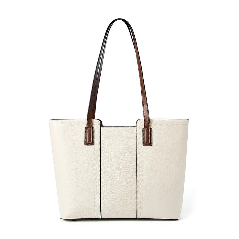 White tote bag with brown handles on a white background