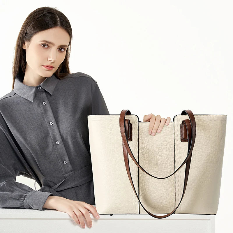 Woman holding a beige tote bag with brown handles on a white background