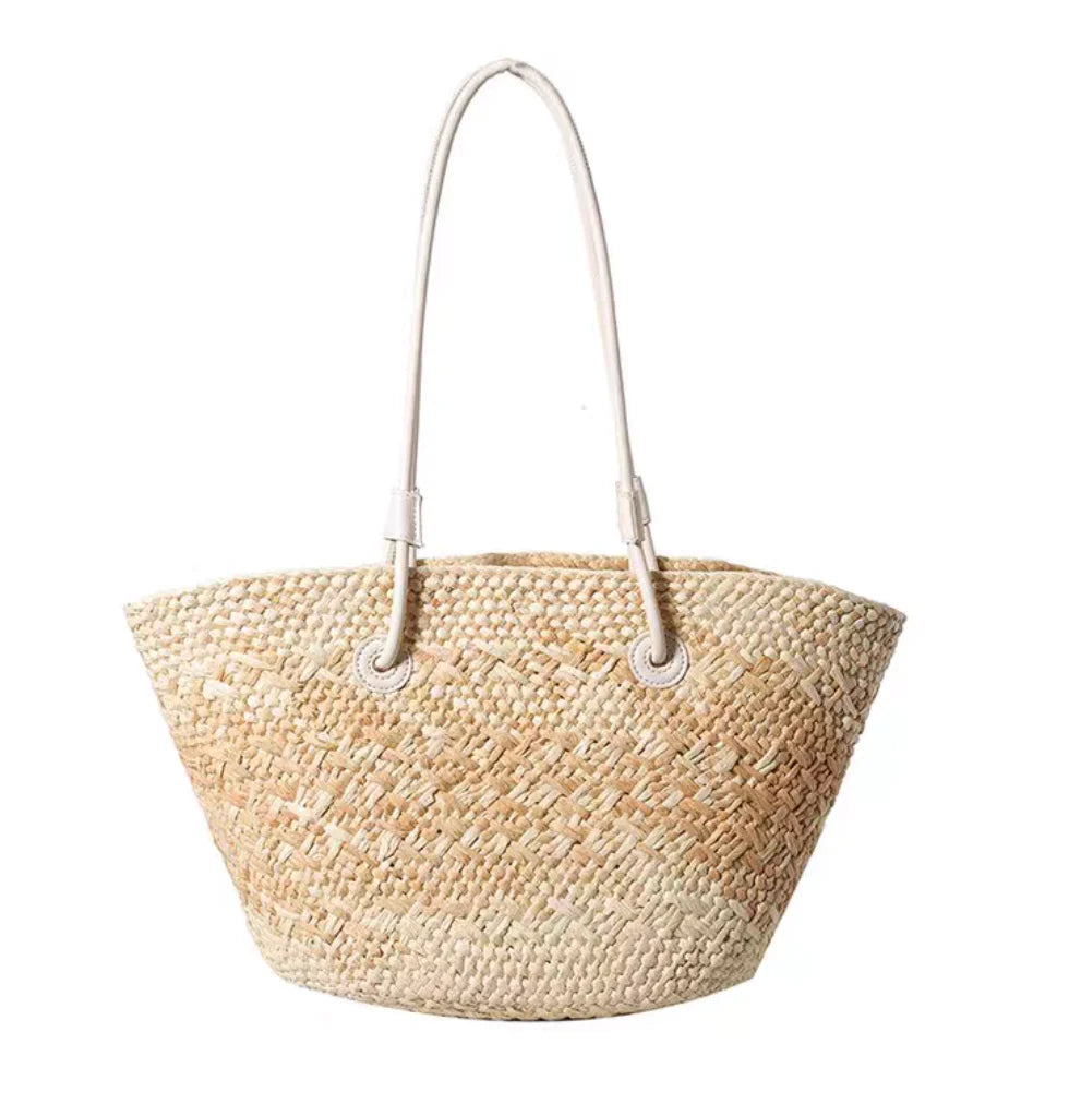 Woven straw bag with a handle on a white background