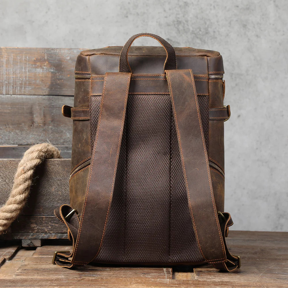 back og the brown leather backpack on the wooden table