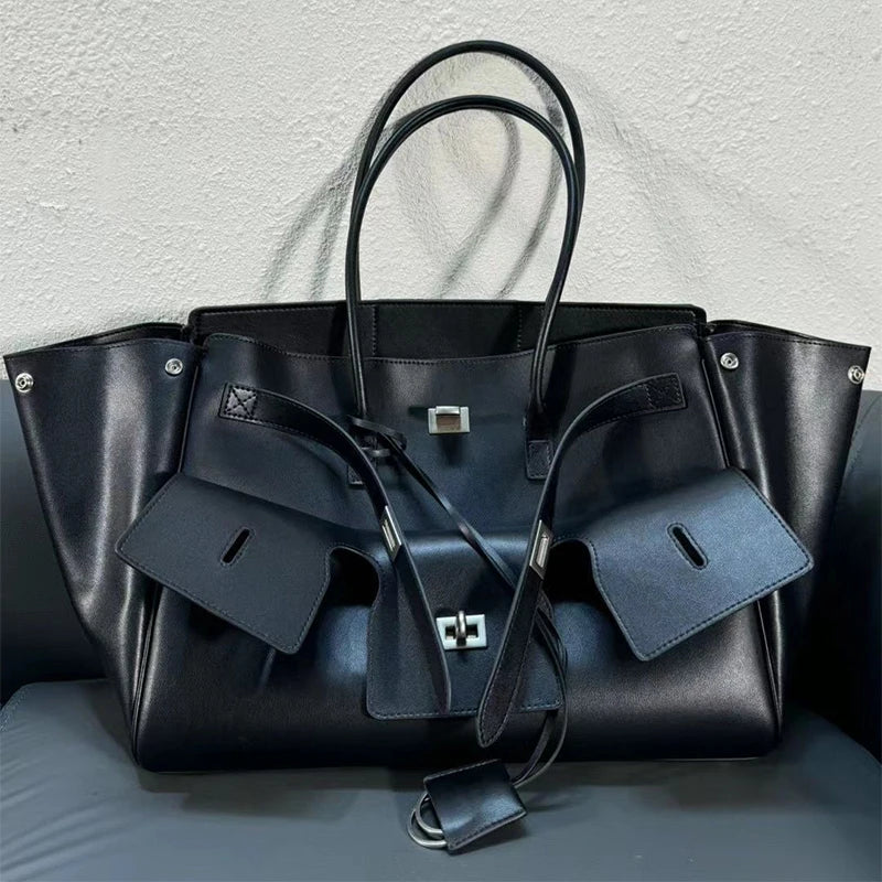 Close-up of a black luxury leather tote bag with silver lock details – elegant and spacious handbag for women.