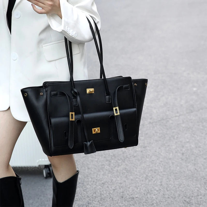 Woman carrying a large black luxury leather tote bag – elegant and spacious handbag for work, travel, and everyday fashion