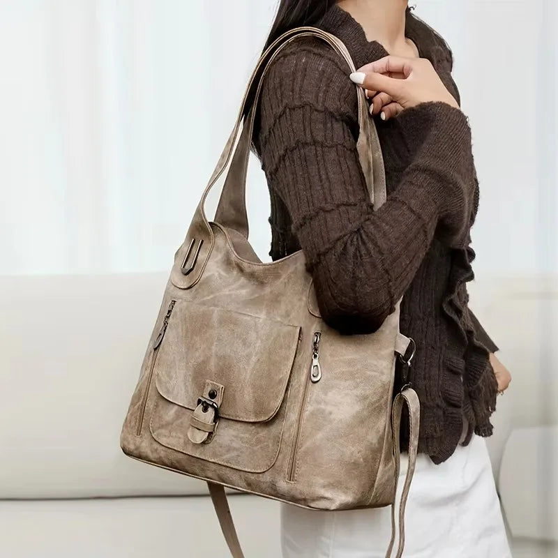 lady in brown top handing the beige handbag