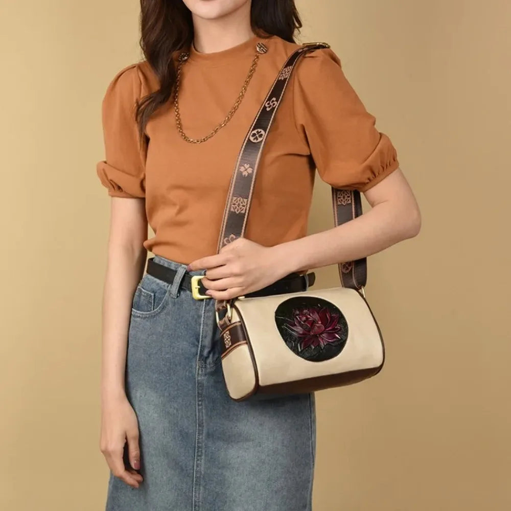 Model wearing a vintage floral crossbody bag with an embossed flower design, featuring an adjustable patterned shoulder strap.